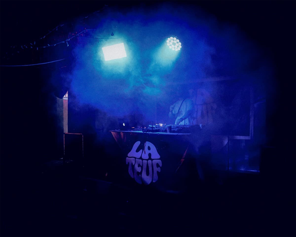Le DJ set sous les lumières bleues, face au logo LA TEUF